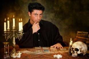 Halloween scene of a young astrologist reading tarot cards